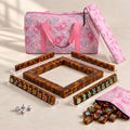 Amber American mahjong starter kit with tortoiseshell tile walls inside four clear racks and a quilted pink paisley carrying set