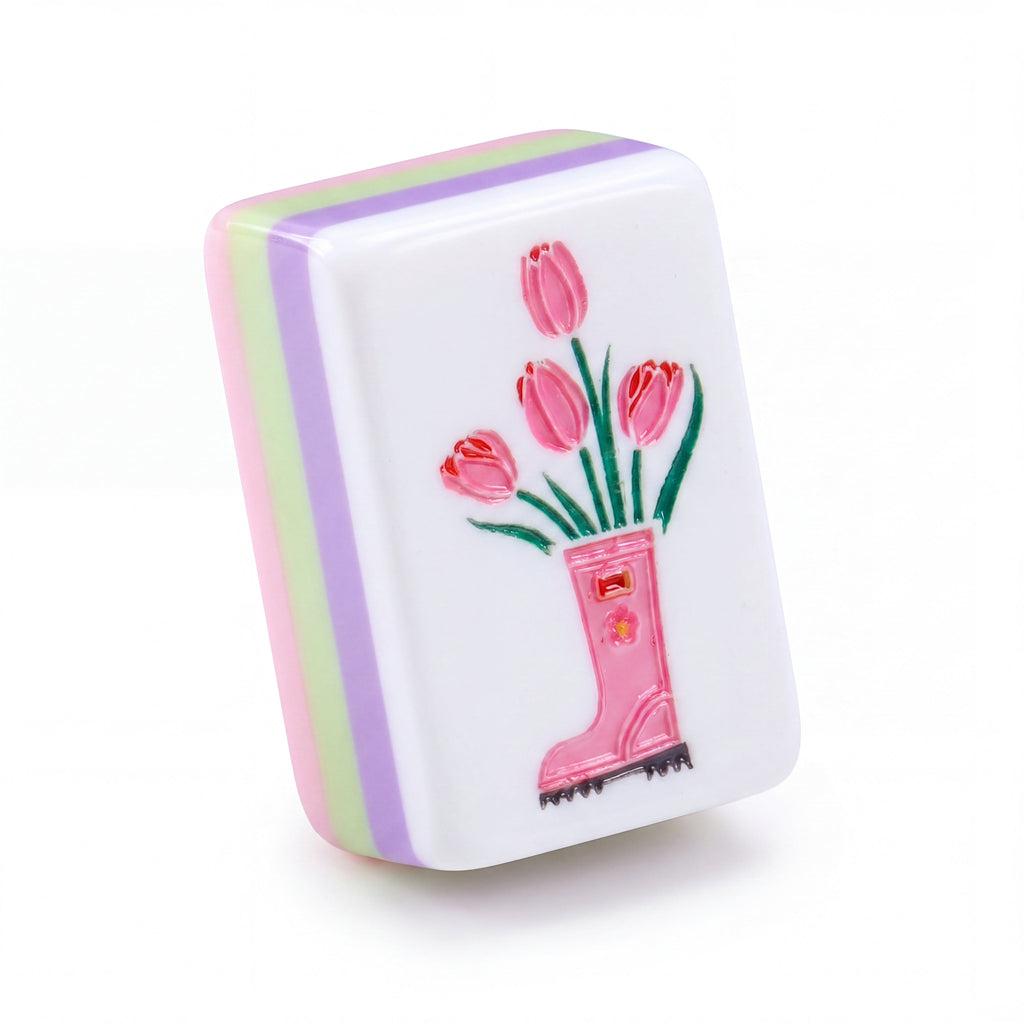 Single Bloomsbury mahjong tile showing pink tulips in a rain boot and the purple, green and pink layered edge