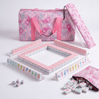 Bloomsbury American mahjong starter kit with pale pink backed tiles walled inside four clear racks, a quilted pink paisley tote, drawstring rack sleeve and zippered tile pouch