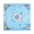 Turquoise mahjong mat with peony and rose bouquets banked into the corners, shown flat from above on white