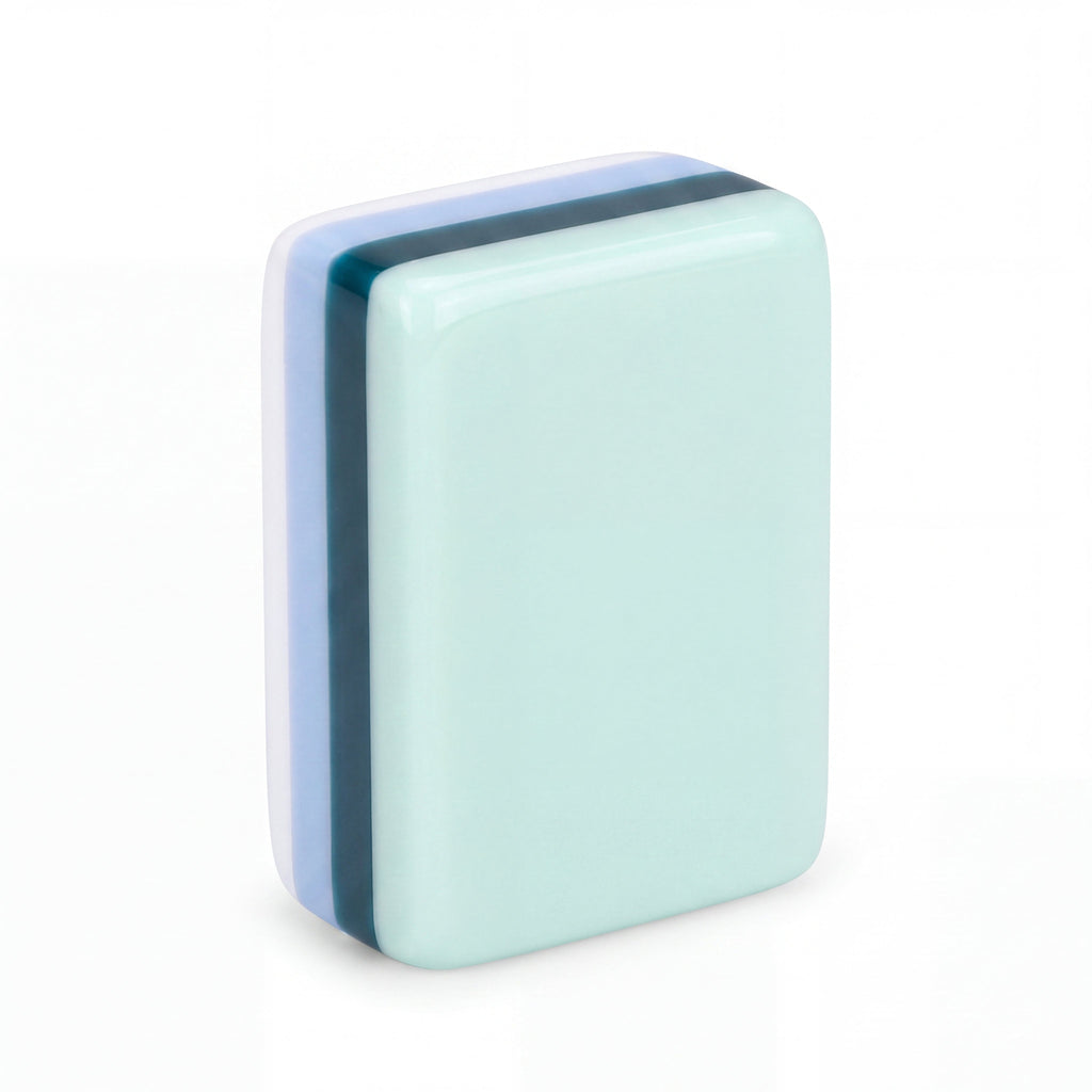 Single Key West mahjong tile from the back, showing the mint green back and striped resin edge