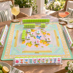 Limoncello American mahjong tiles set up for a game on a lemon print mat on a sunny terrace, with lime green tile walls and racks