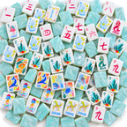 Mermaid American mahjong tiles scattered face up and face down, showing pearly aqua backs