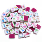 Palm Beach Pink American mahjong tiles scattered face up and face down, showing magenta backs and green and pink layered edges