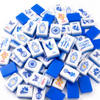 Porcelain American mahjong tiles scattered face up and face down, showing cobalt blue backs and pale blue layered edges