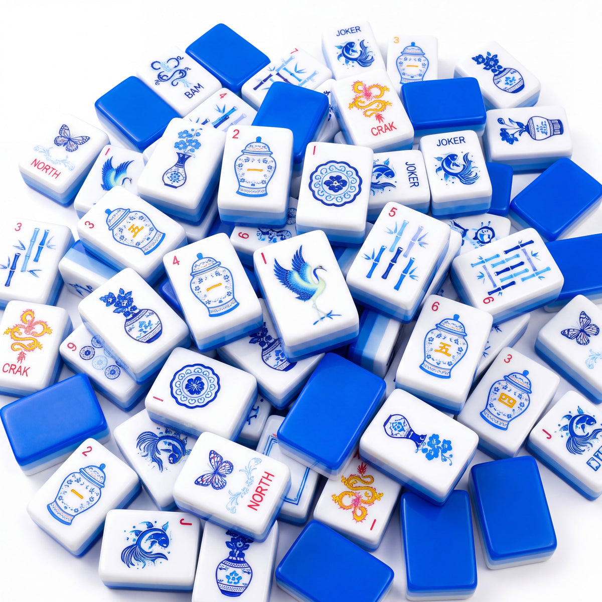 Porcelain American mahjong tiles scattered face up and face down, showing cobalt blue backs and pale blue layered edges