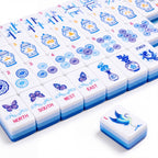 Porcelain American mahjong tiles in rows, showing the blue and white ginger jar craks, bamboo bams, porcelain medallion dots, butterfly winds and the crane joker