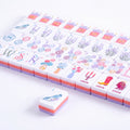 Violette mahjong tiles laid flat in rows with the candlestick, cowboy boot and cocktail jokers in the front row
